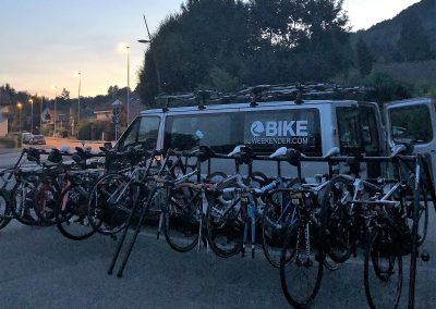 Road bikes on a rack by a minibus